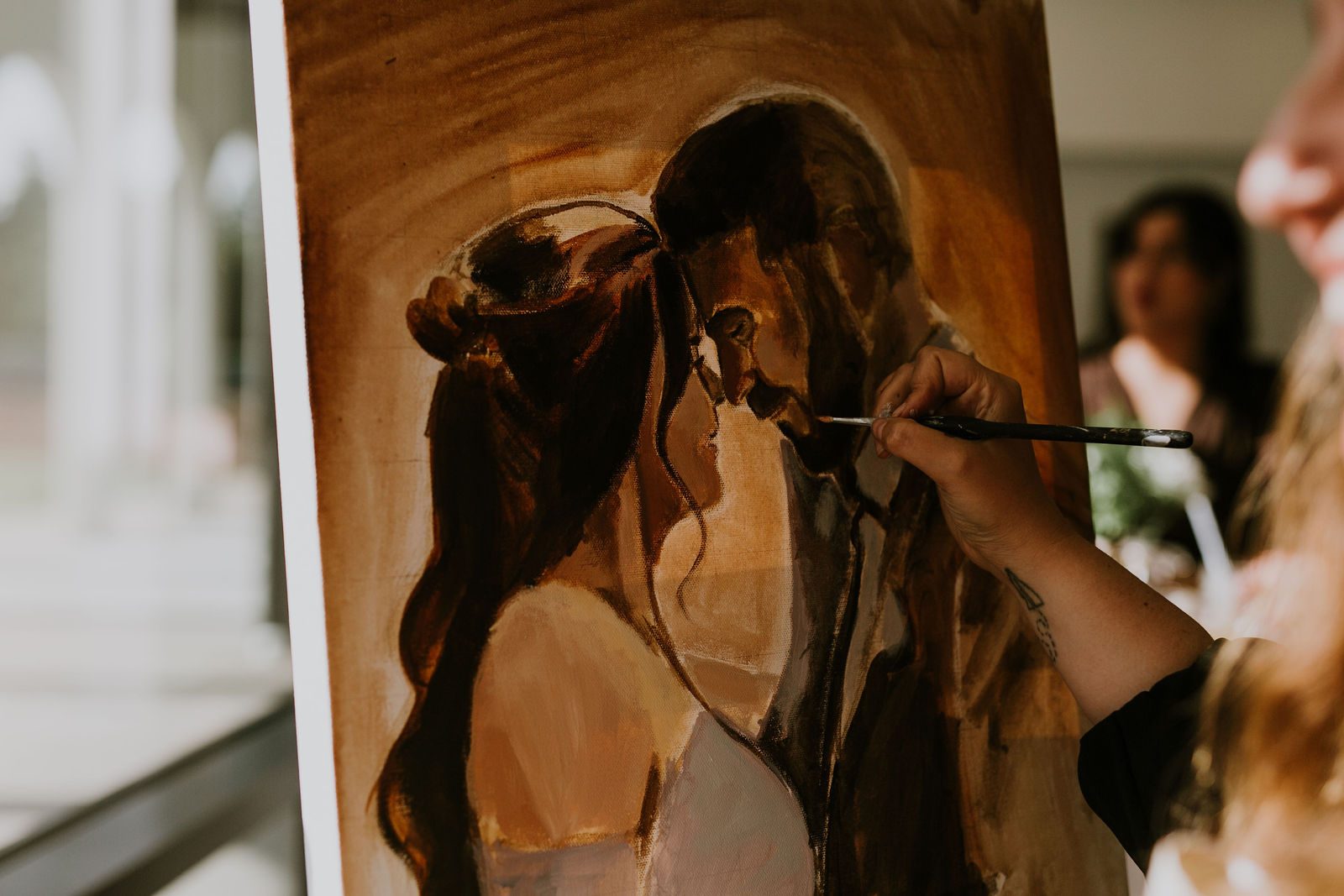 A close-up of Heather's brush building up the painting on canvas